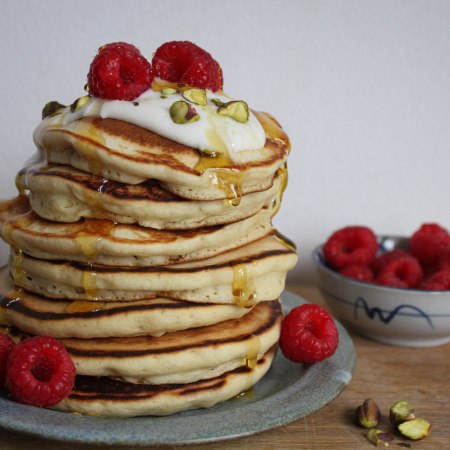 Vegan pancake stack with raspberries and syrup